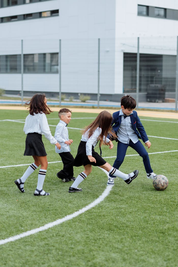 Group of children playing soccer on a school field, enjoying outdoor fun and recreation.